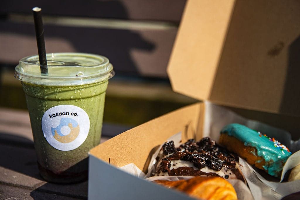 A kasdan co. iced drink and a box of fresh donuts